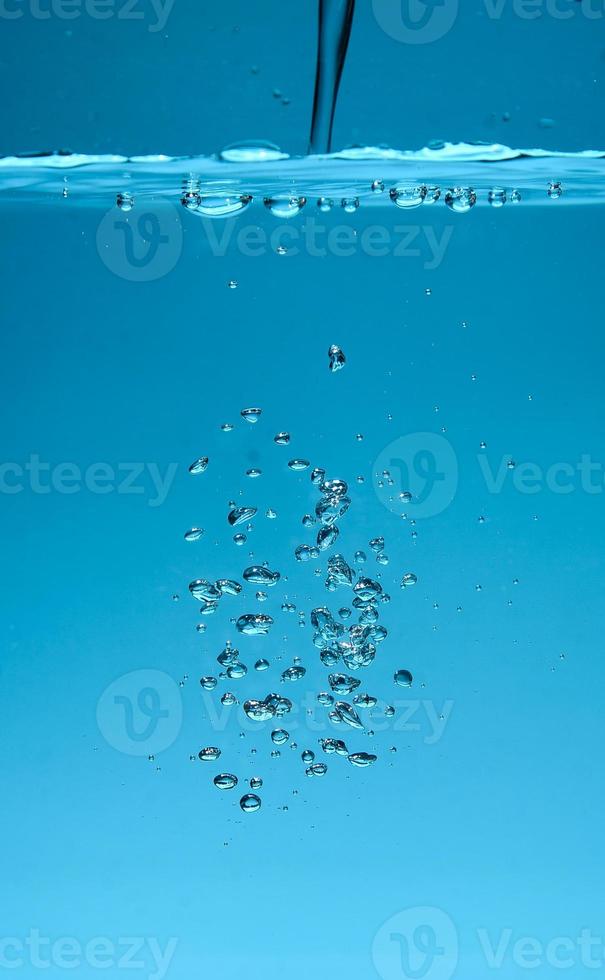 abstracte achtergrondafbeelding van bellen in water. schoon water met waterdruppels en golven. zoet water een glas met bubbels blauwe achtergrond. foto