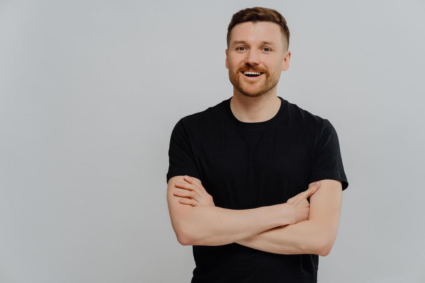 positieve jonge man poseren in studio met blije gezichtsuitdrukking foto