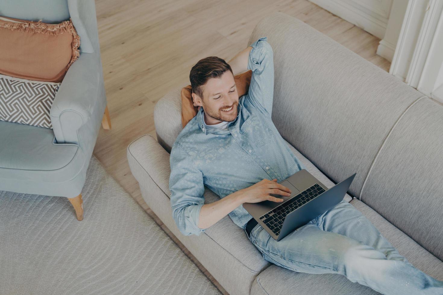 jonge bedrijfsmedewerker in vrijetijdskleding ontspannen na succesvolle online presentatie foto