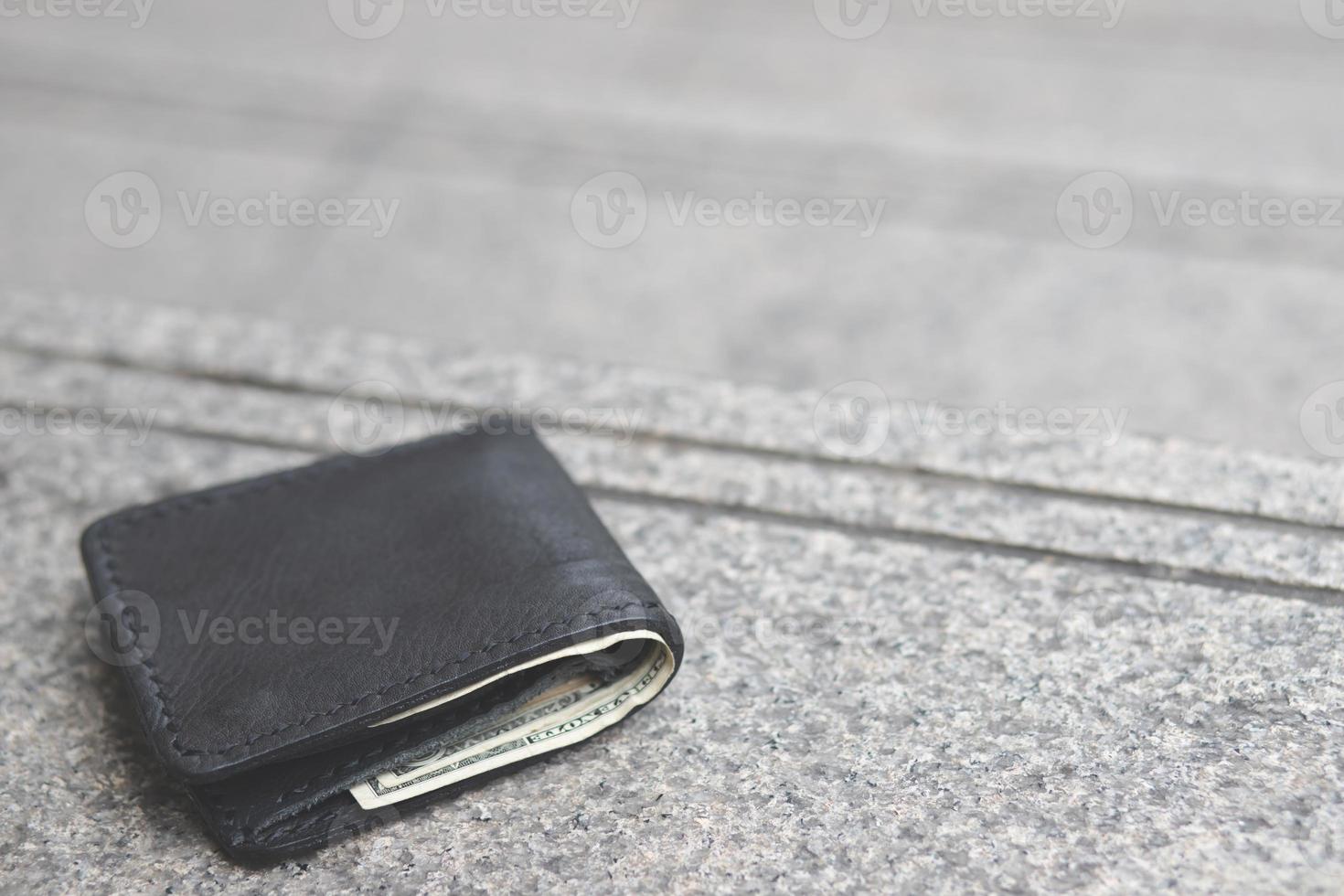 de zwarte portemonnee viel op het openbare pad foto