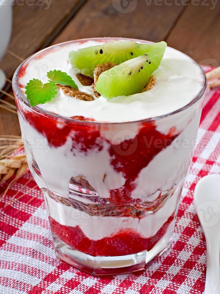 gezond dessert met muesli en fruit in een glazen kom op tafel foto