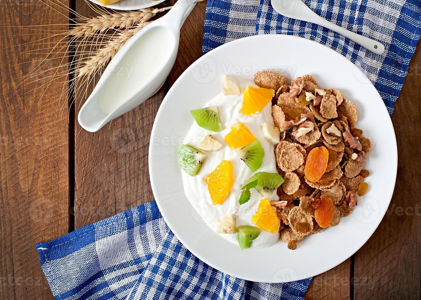 gezond dessert met muesli en fruit in een wit bord op tafel foto