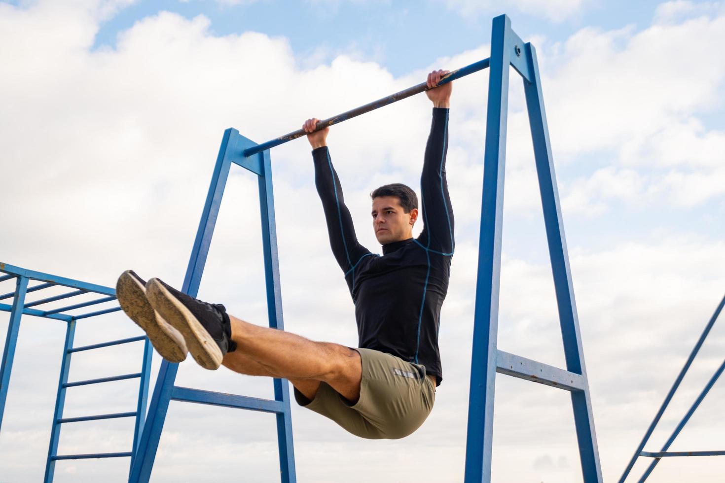 jonge fit mannelijke training doe oefeningen buiten op het strand foto