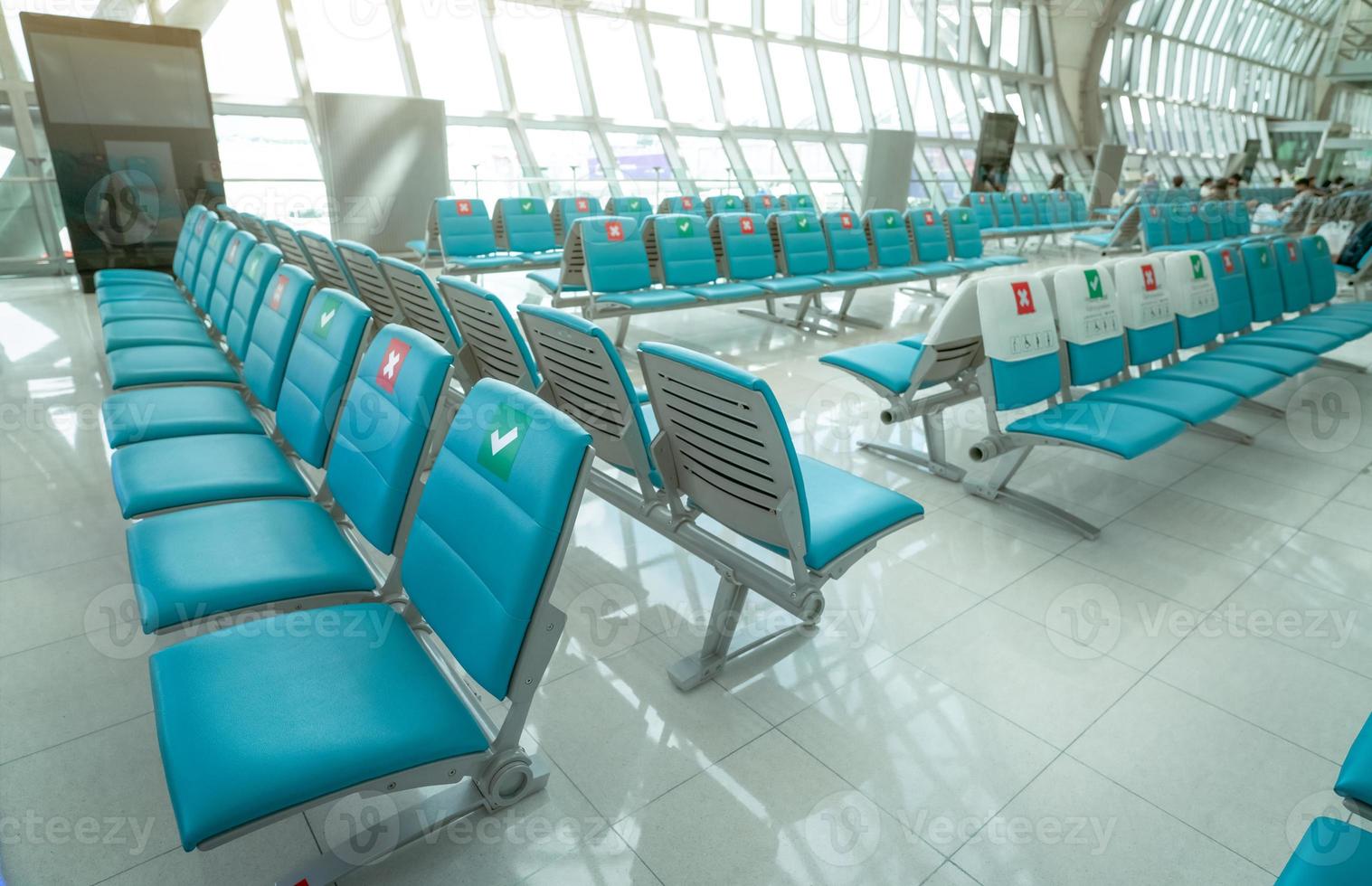 stoel in de vertreklounge op de luchthaventerminal. afstand voor één stoel houd afstand om het coronavirus te beschermen en de sociale afstand van passagiers voor de veiligheid. lege stoel op de luchthaven. luchtvaart bedrijfscrisis foto