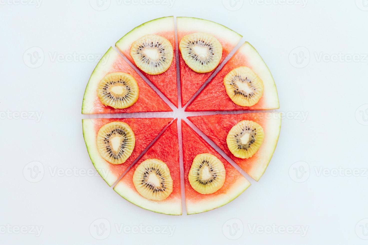 heerlijk zomers dessert. watermeloen pizza met plakjes kiwi geïsoleerd op witte achtergrond. voedsel kunst concept. zoet tussendoortje. vers seizoensfruit gerecht foto