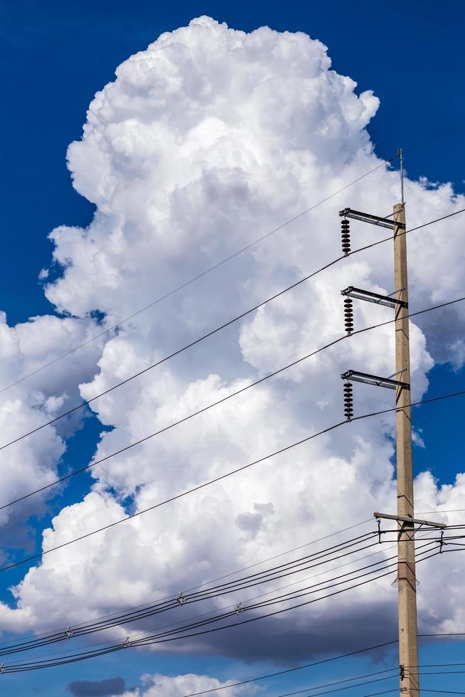 witte wolken in de lucht in de buurt van de elektriciteitspalen. foto