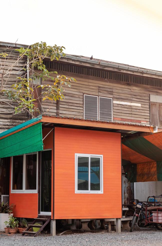 oranje kamer cabine in de buurt van het oude houten huis. foto