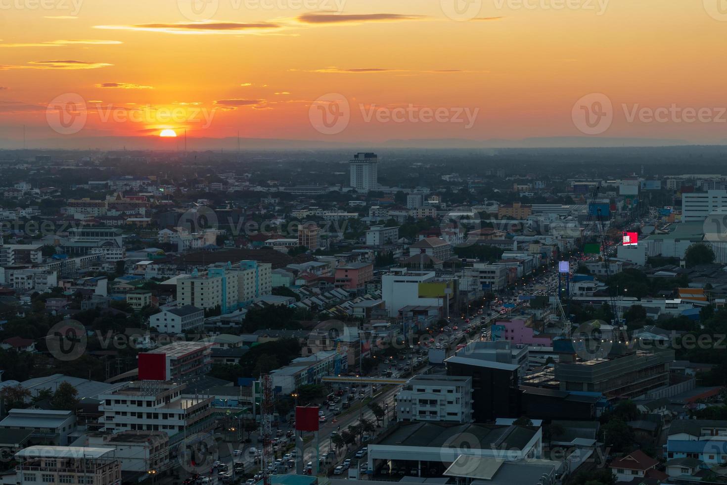 een uitzicht vanaf de top van de vele gebouwen die het verkeer van auto's op de wegen huisvesten in een van de provinciehoofdsteden van thailand tijdens de prachtige zonsondergang in de schemering. foto