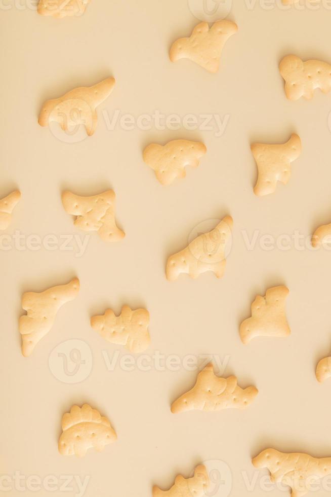 koekjespatroon in de vorm van dinosaurussen bovenaanzicht op een beige achtergrond. zwart-wit foto