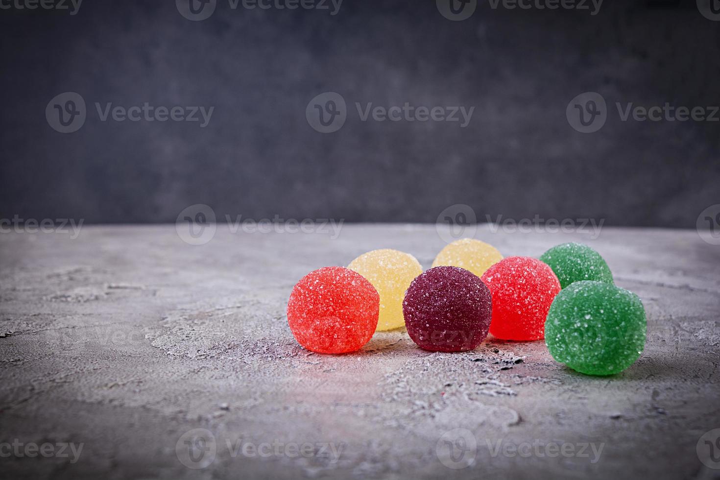 kleurrijke marmelade op grijze achtergrond. heerlijke jujube-ballen. foto