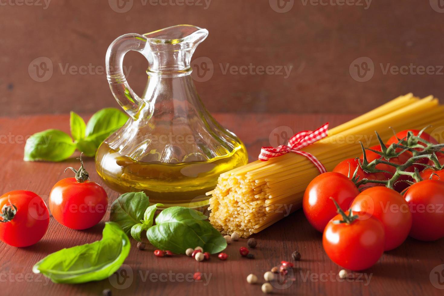 rauwe pasta olijfolie tomaten. Italiaanse keuken in rustieke keuken foto