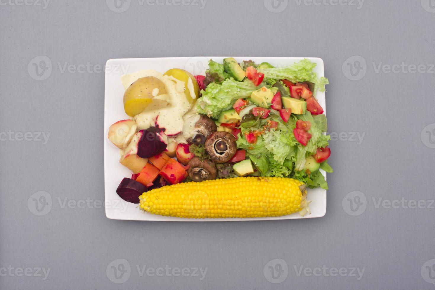 salade met avocado en tomaat met aardappelen, wortelgroenten en mais foto