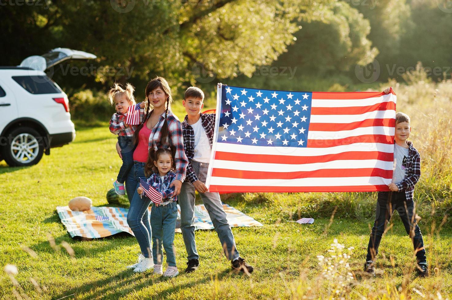 Amerikaanse familie. moeder en vier kinderen. met Amerikaanse vlaggen. Amerika vieren. foto