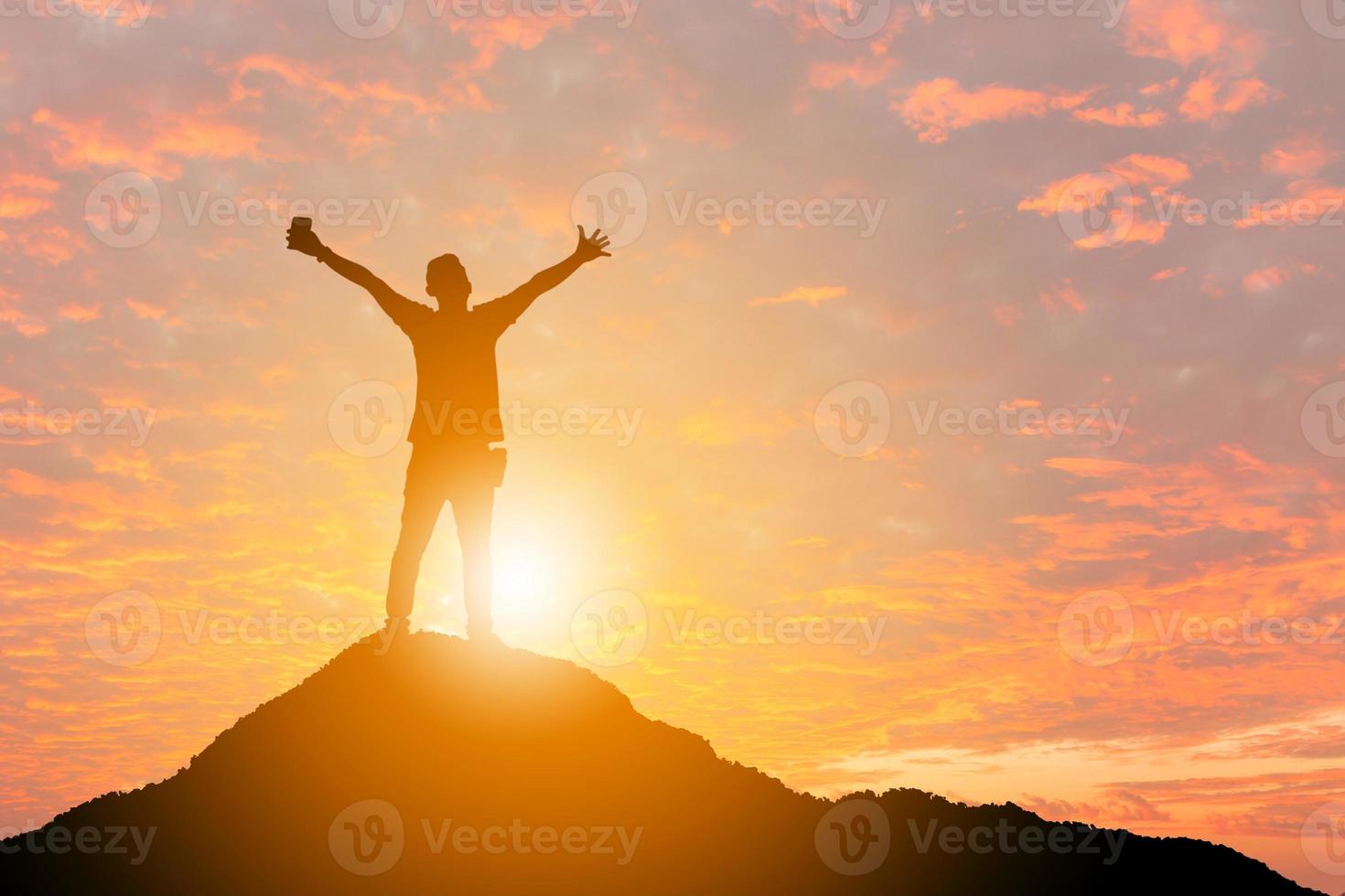 silhouet van man viering succes geluk op een bergtop zonsondergang avond hemelachtergrond, sport en actief leven concept. foto