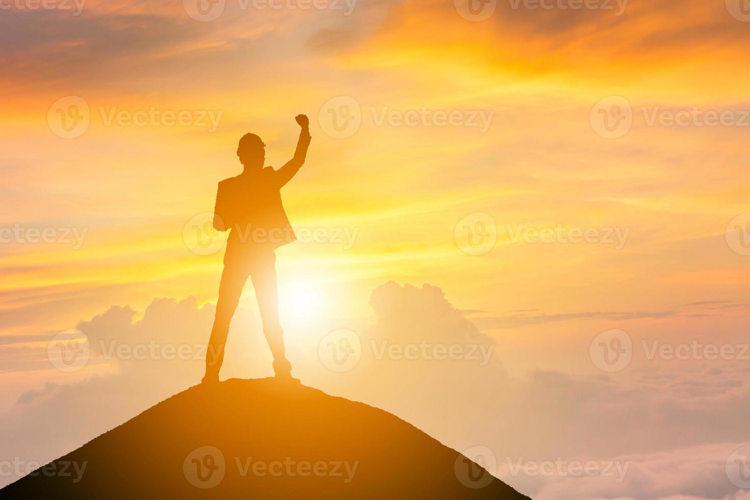 silhouet van business man viering succes geluk op een bergtop zonsondergang avond hemelachtergrond, sport en actief leven concept, met uitknippad. foto