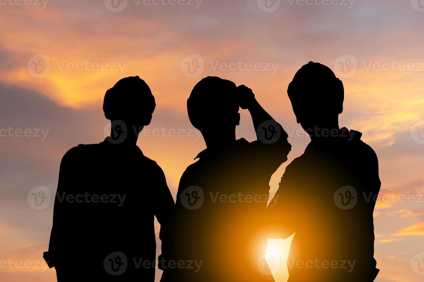 succes en groepswerkconcept, silhouet van ingenieur en arbeidersteam met het knippen van weg die zich met zonsondergangachtergrond bevinden foto