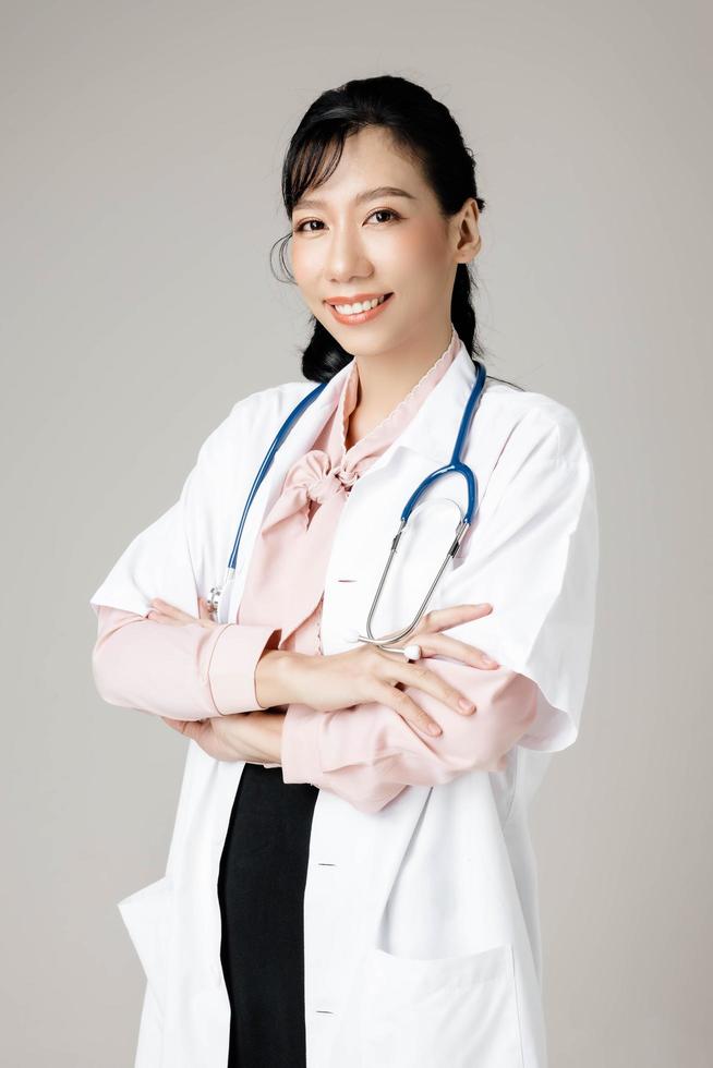 portret van een aantrekkelijke jonge vrouwelijke arts in witte jas. foto