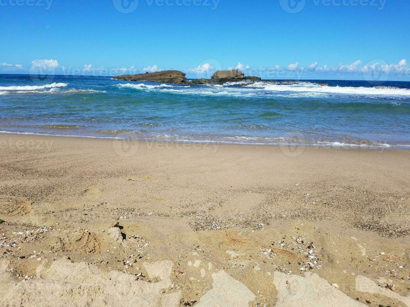 oceaanwater en golven met zand op het strand in isabela, puerto rico foto