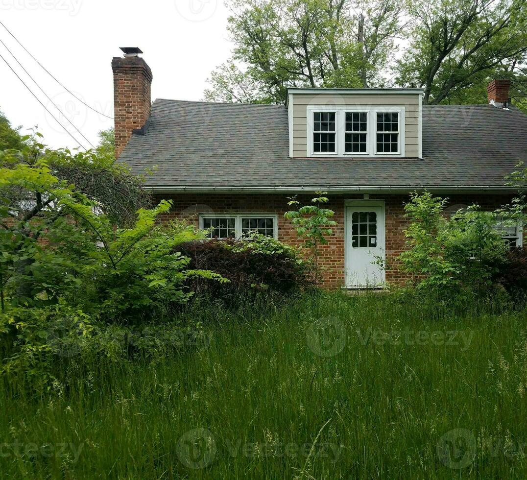 verlaten huis of ruïnes met hoog gras foto