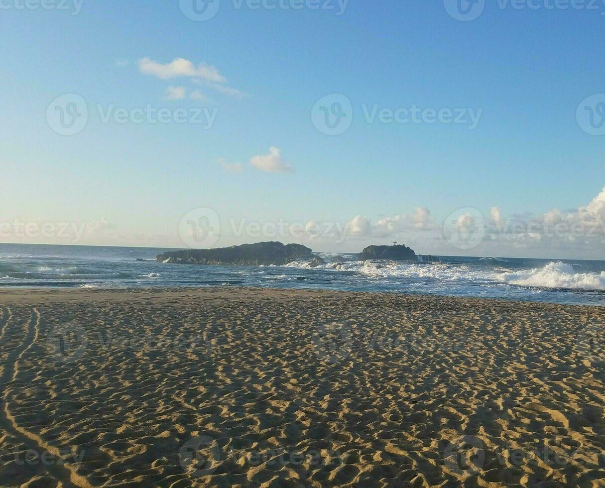 zand en golven op het strand in isabela, puerto rico met kruis foto