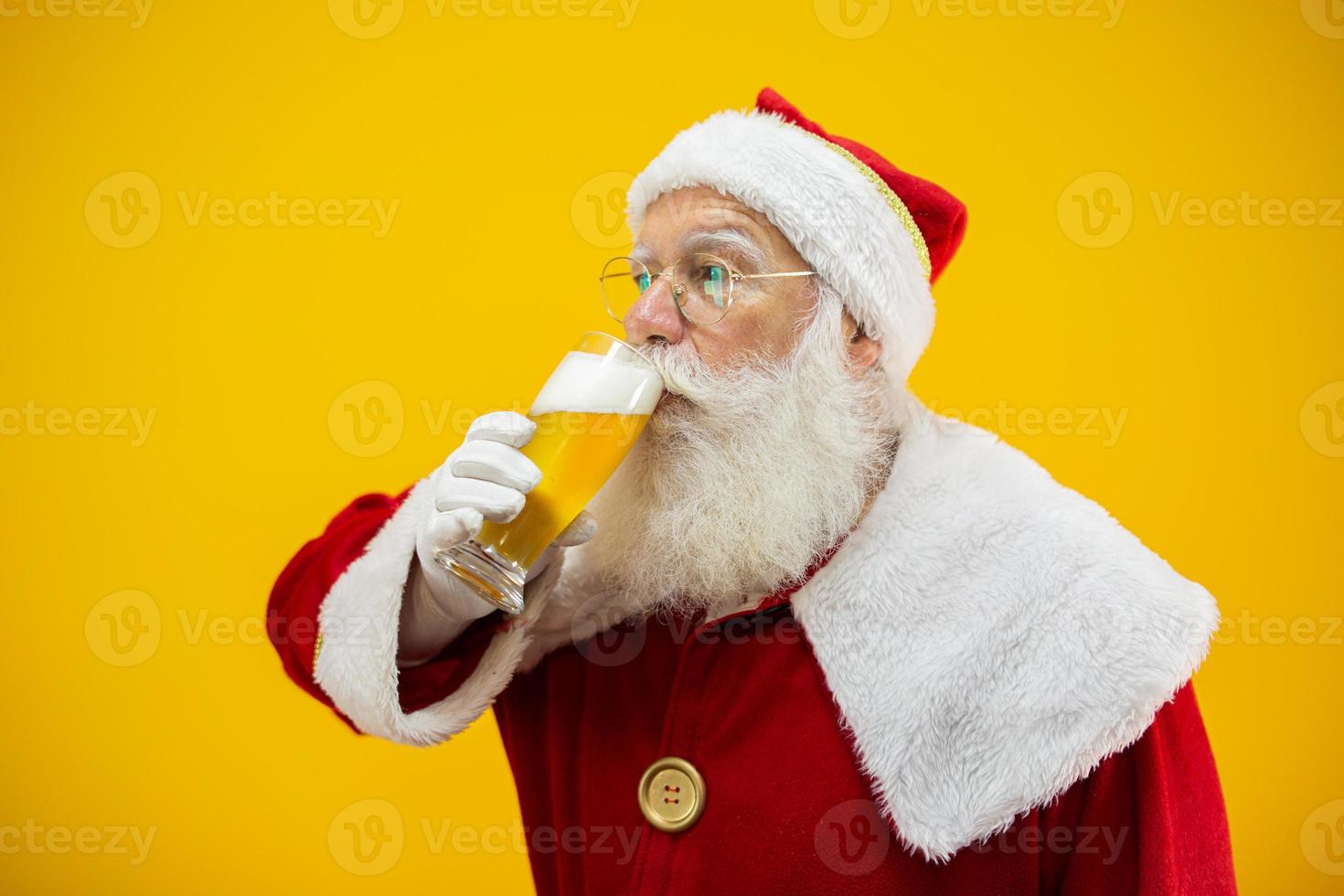 de kerstman drinkt een glas bier. rusttijd. alcoholische drank tijdens de feestdagen. met mate drinken. ambachtelijk bier. Vrolijk Kerstfeest. foto