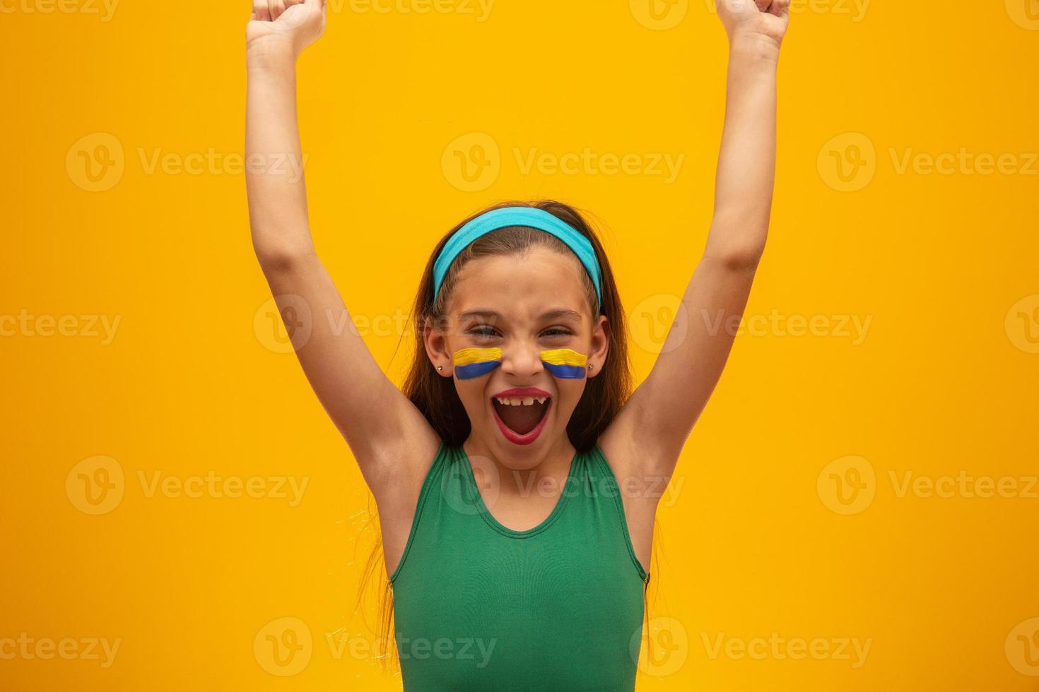 voetbalsupporter, braziliaans team. wereldbeker. mooi klein meisje juichen voor haar team op gele achtergrond foto