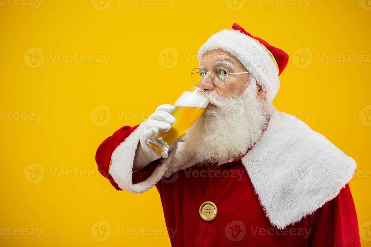 de kerstman drinkt een glas bier. rusttijd. alcoholische drank tijdens de feestdagen. met mate drinken. ambachtelijk bier. Vrolijk Kerstfeest. foto