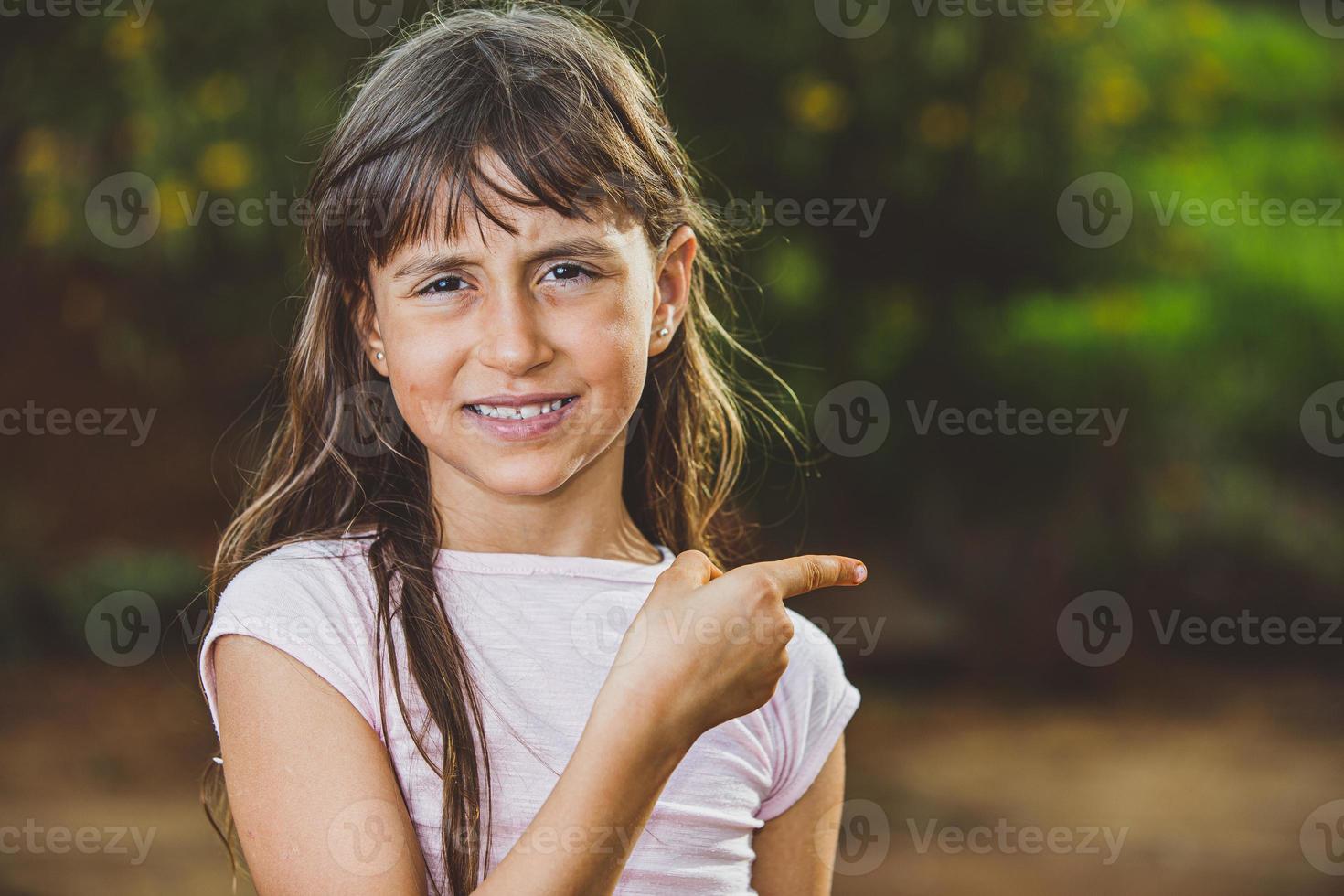 portret van lachende mooie jonge meisje op boerderij wijzende kant. meisje op boerderij in zomerdag. activiteit tuinieren. Braziliaans meisje. foto