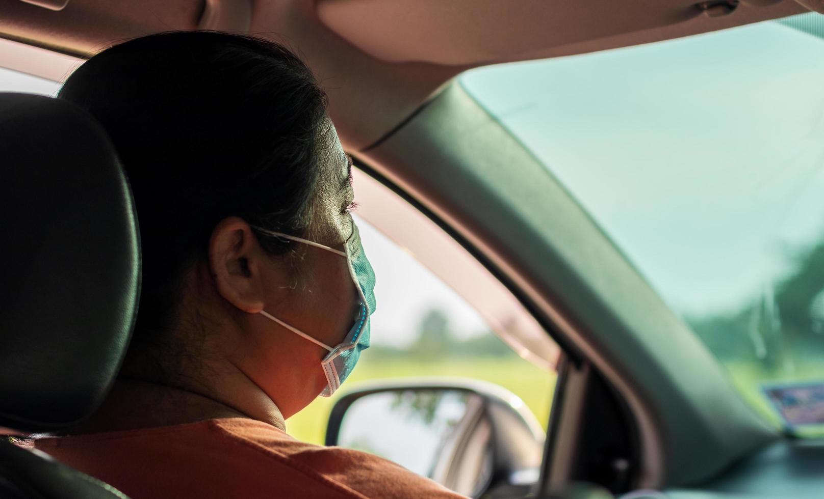 phichit, thailand, 24 juli 2020 - vrouw met gezichtsmasker zittend in een auto foto