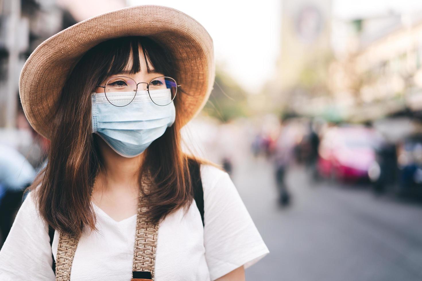 jonge aziatische schattige reiziger draagt een masker en beschermt het virus covid voor een nieuwe normale levensstijl. foto