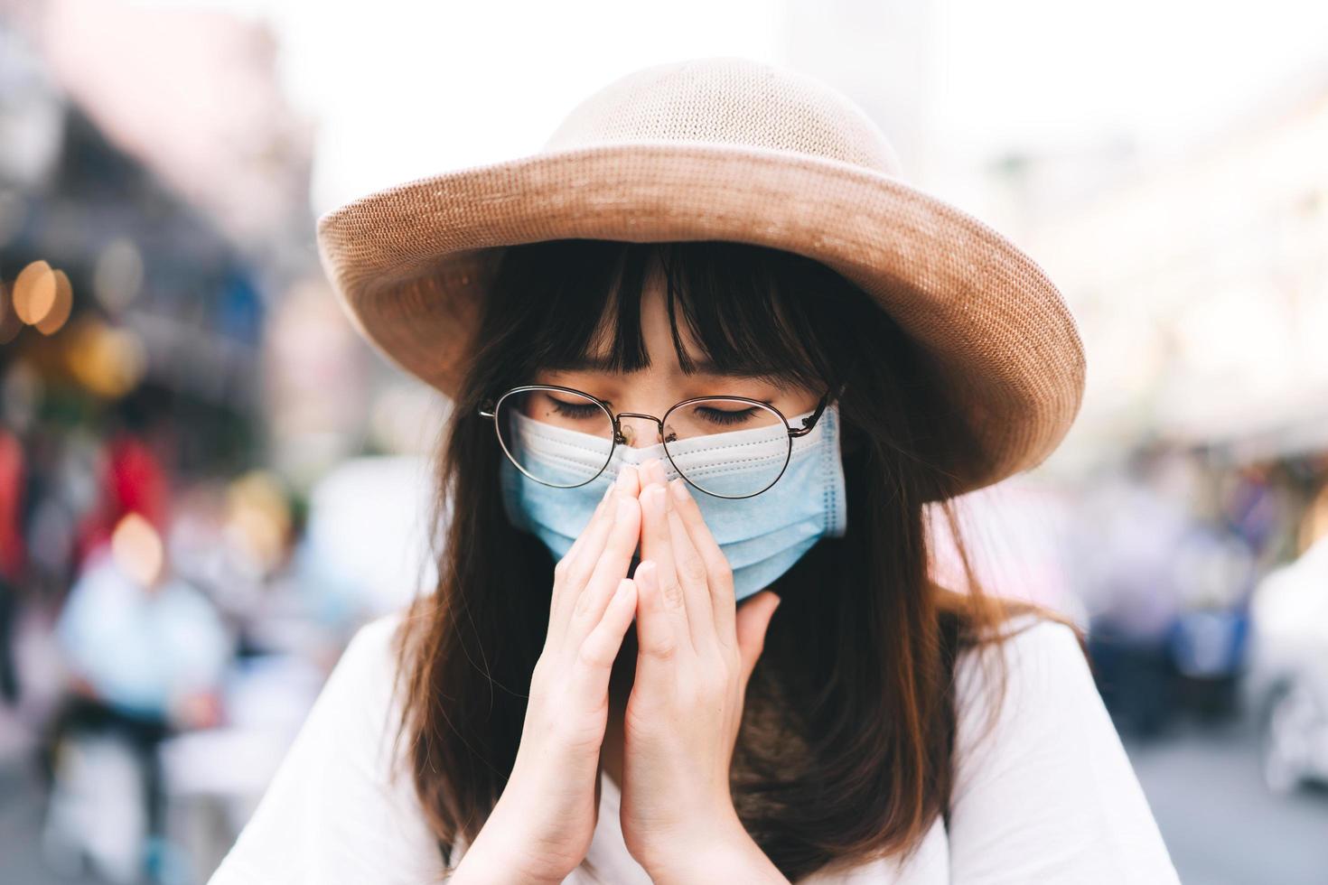 jonge Aziatische reizigersvrouw heeft op dag buiten met masker geniesd foto