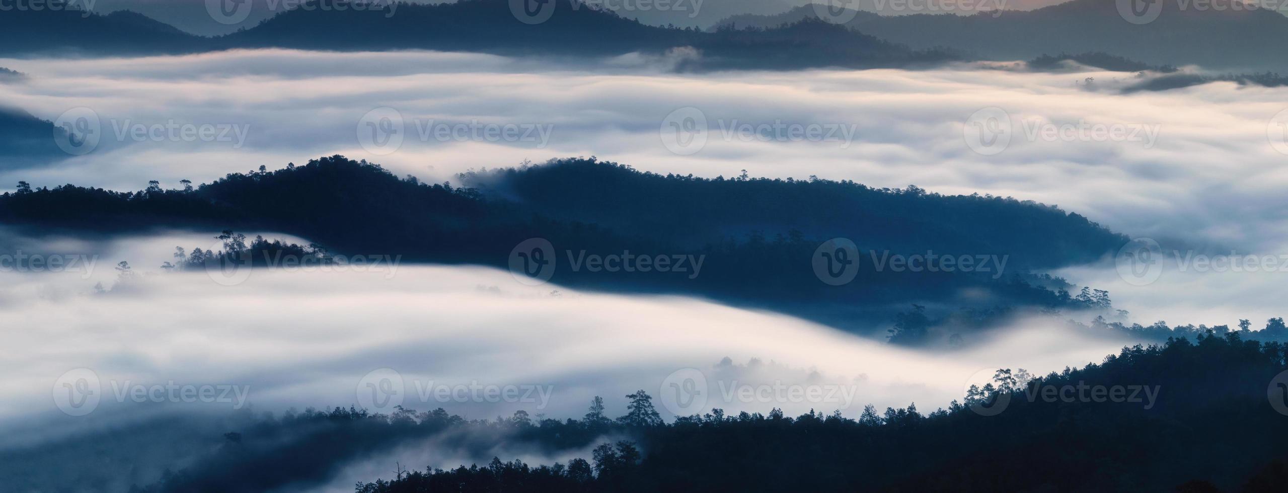 mistig stromend op de bergketen in de vallei op het platteland foto