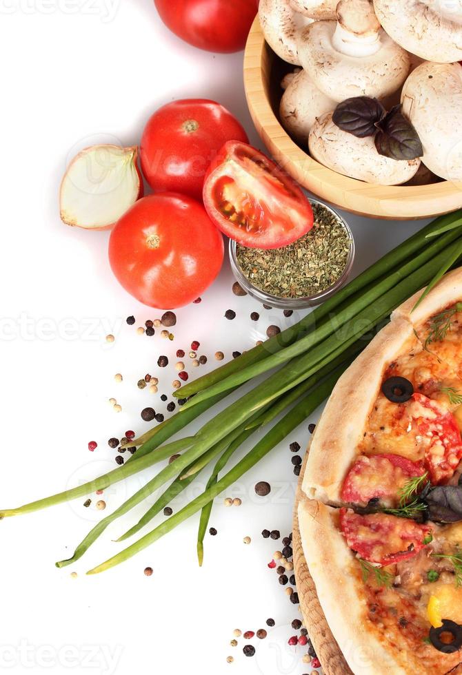 heerlijke pizza, groenten, kruiden en olie op wit wordt geïsoleerd foto