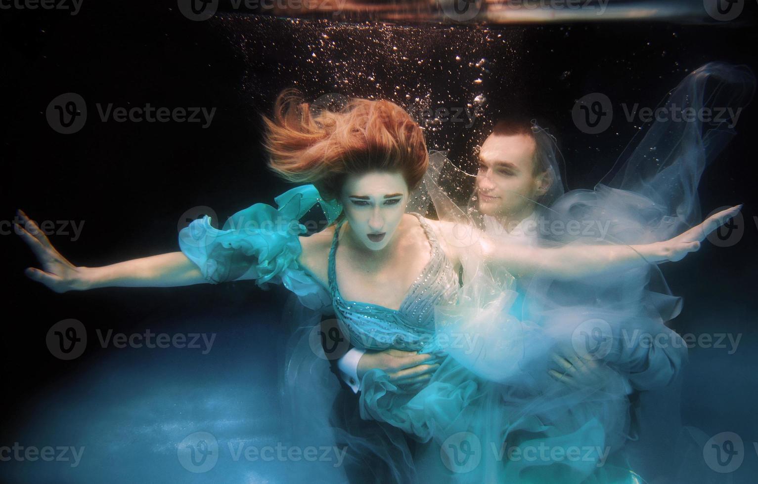 mooi paar dat onder water danst in het zwembad foto