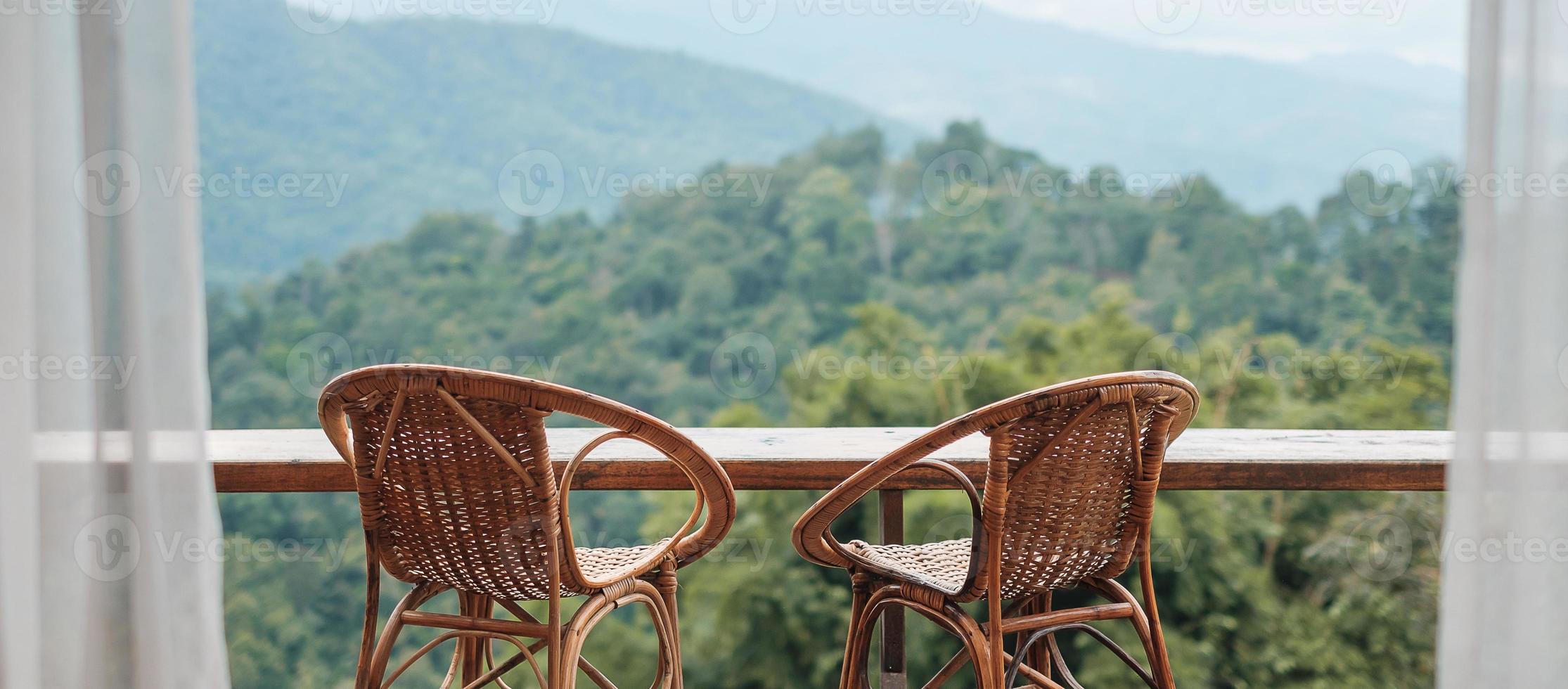 paar stoelen op het balkon van een huis op het platteland of een gastgezin met uitzicht op de bergen in de ochtend foto