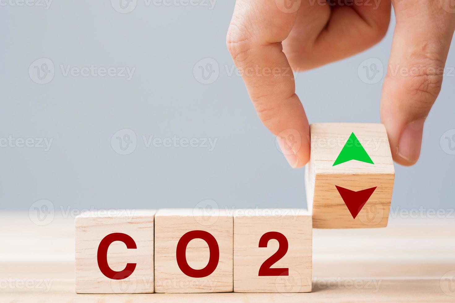hand flipping houten kubusblokken naar boven en beneden pijlsymbool met co2 kooldioxide tekst op tabelachtergrond. gratis koolstof, alternatieve energie en wereldwijde klimaatveranderingsconcepten foto