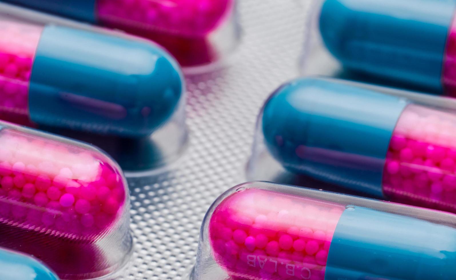 close-up kleurrijke blauwe, roze capsule met korrel in zijpillen. pillen in blisterverpakking. farmaceutische doseringsvorm en verpakking. anti-schimmel medicijn. foto