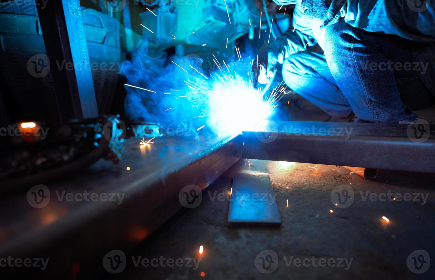 lasser las metaal met argon booglasmachine en heeft lasvonken. een man draagt beschermende handschoenen. veiligheid op de industriële werkplek. lasser werken met veiligheid. arbeider in de fabriek van de staalindustrie. foto