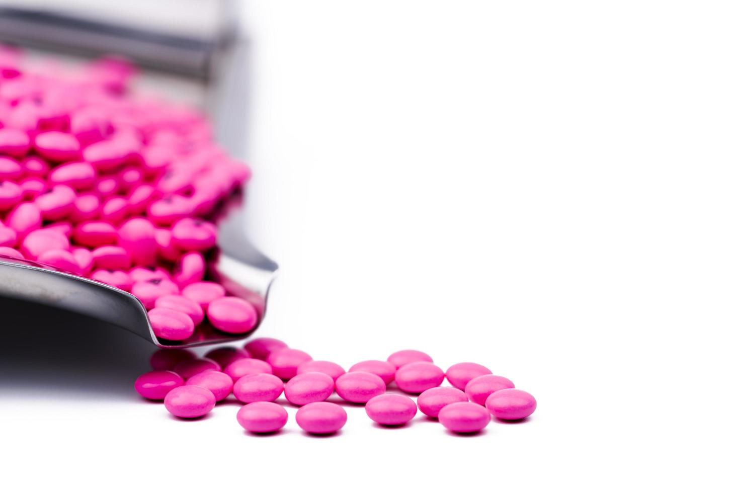 stapel roze ronde suiker gecoate tabletten pillen op drugsdienblad met kopieerruimte. pillen voor de behandeling van anti-angst, antidepressiva en migraine-hoofdpijn profylaxe. gezondheidszorg bij senioren of ouderen foto