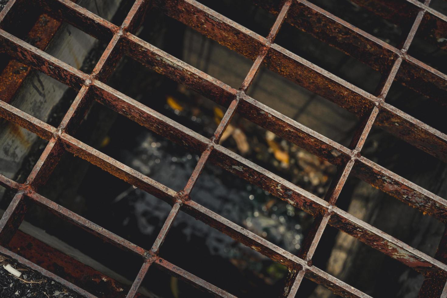 bovenaanzicht van oud en roestig metaal bedekt met straatafvoerslang. roest metalen textuur achtergrond. zout water versnelt roest. oppervlak van metaal in bouwplaats in de buurt van de zee. foto