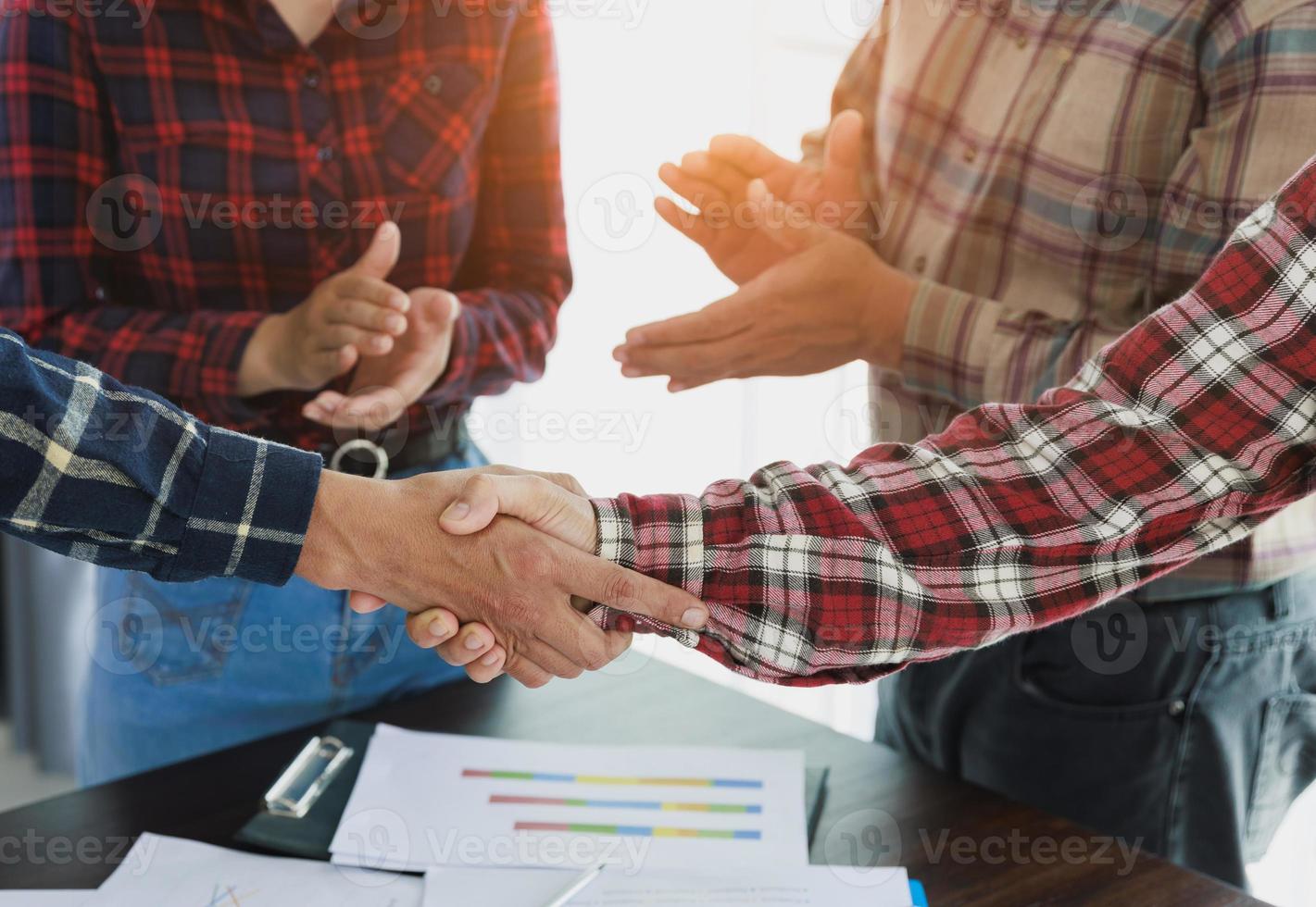 jonge ondernemers handen schudden. het afsluiten van een succesvolle vergadering. teamwerk. foto