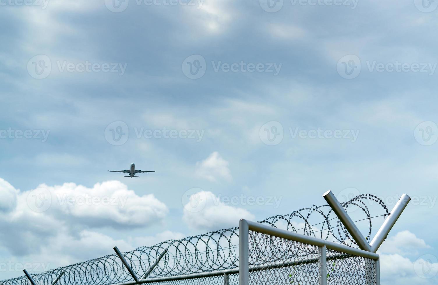 vliegtuig vliegen op blauwe lucht en witte wolken boven metalen hek. luchtvaart zaken. commercieel vliegtuig. luchttransport. hek voor veiligheid en beveiliging. luchtvaart zaken. Met het vliegtuig reizen. foto