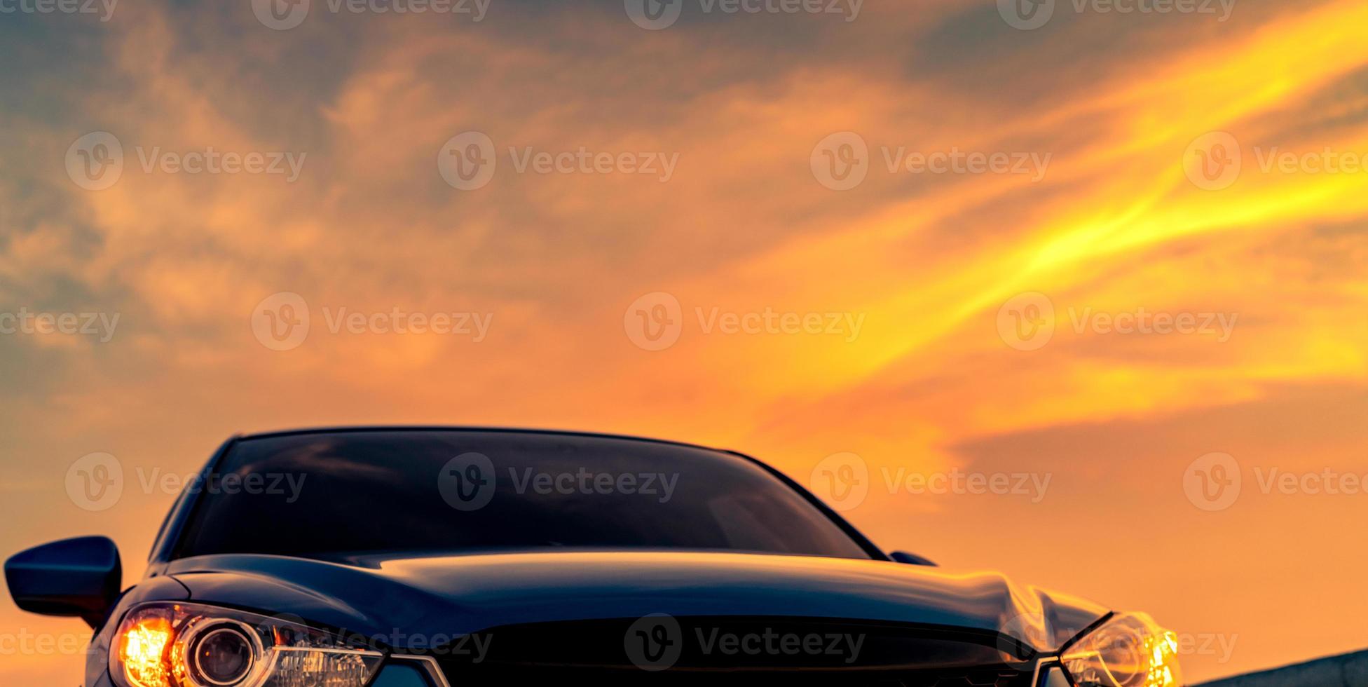 vooraanzicht blauwe compacte suv auto met sport en modern design geparkeerd op weg met zonsondergang hemelachtergrond. elektrische auto technologie en business. hybride auto en auto. tropische roadtrip reizen. foto