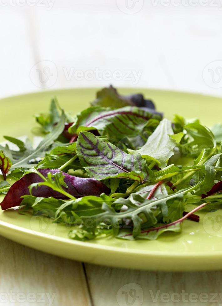 mengsel van salade op een houten achtergrond foto