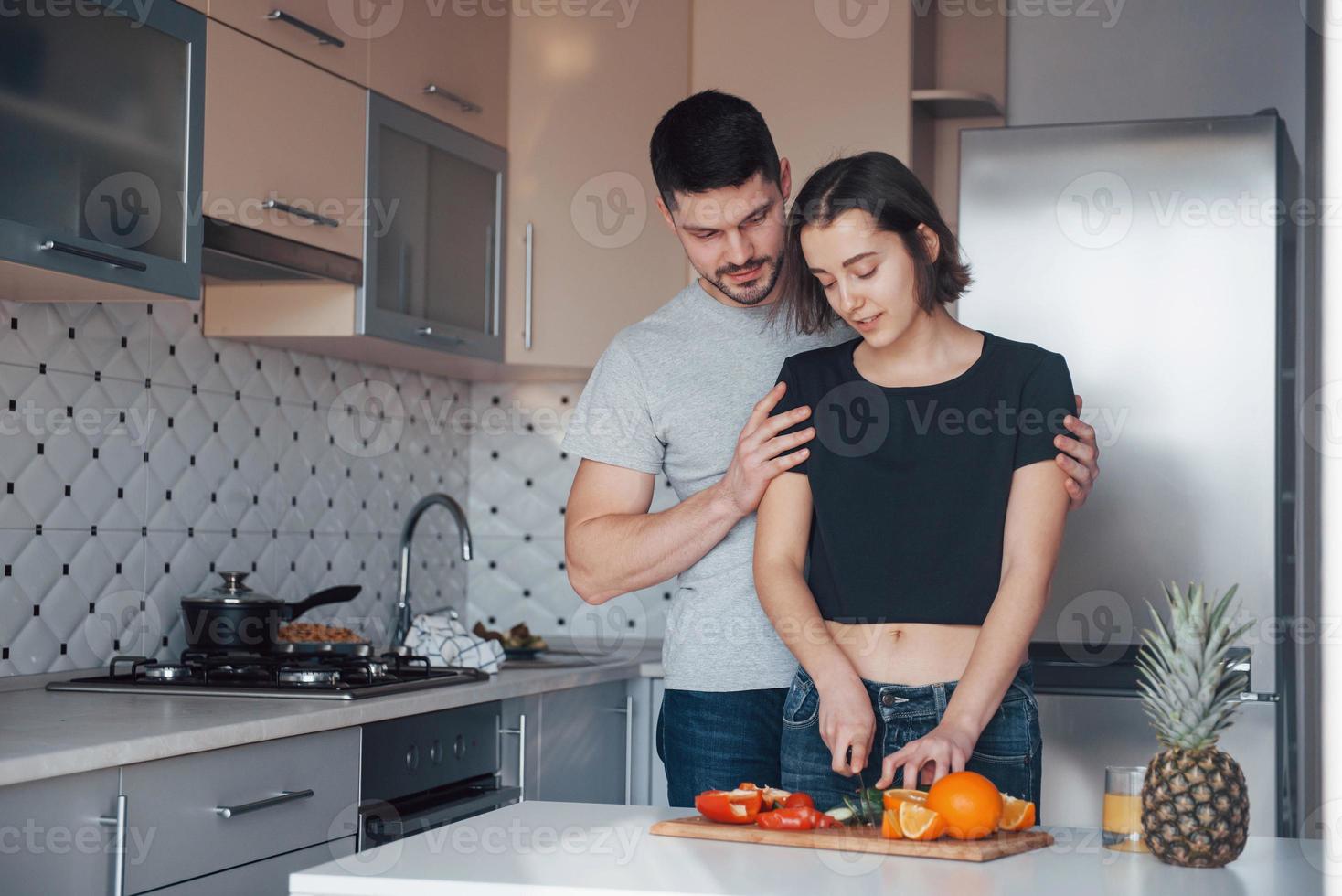 handen op de schouders. jong stel in de moderne keuken thuis in hun weekendtijd in de ochtend foto