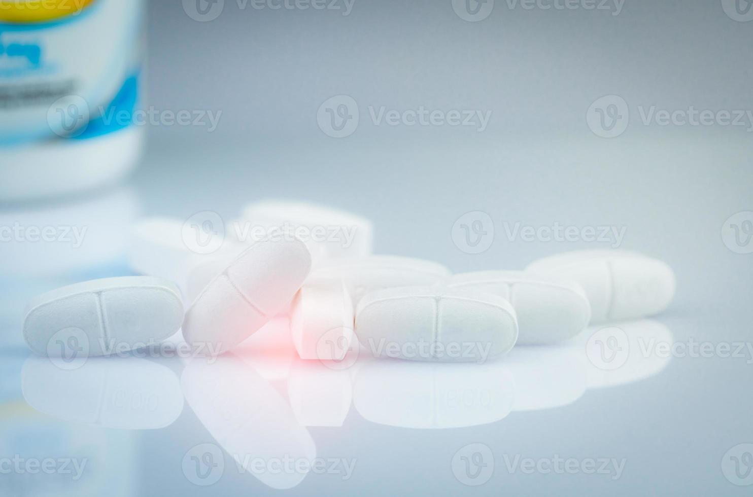 calciumtabletten voor kinderen of zwangere vrouwen. witte tabletten pillen op de wazige achtergrond van de medicijnfles. vitamines en supplement concept. farmaceutische industrie. apotheek producten. wereldwijde gezondheidszorg. foto