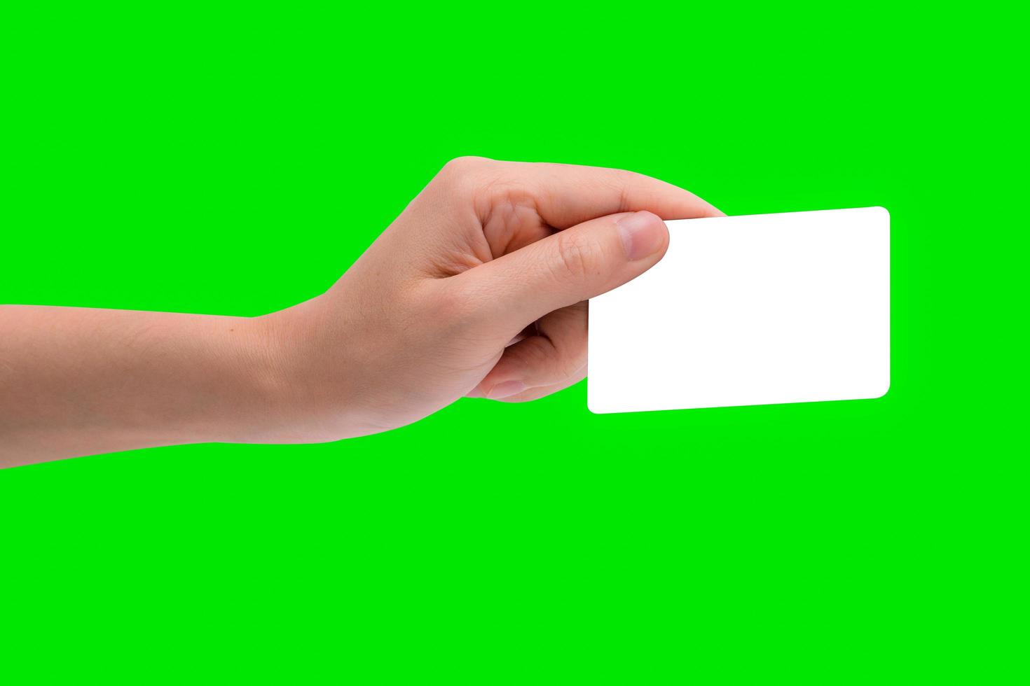 hand houden visitekaartje, creditcard of blanco papier geïsoleerd op groene achtergrond met uitknippad. foto