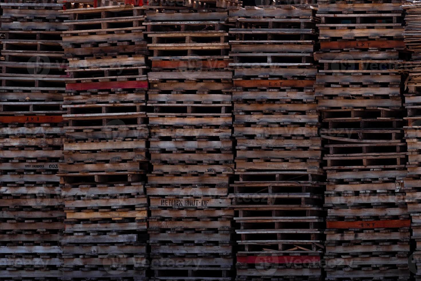 stapel oude houten pallet. industriële houten pallet gestapeld in fabrieksmagazijn. vracht- en verzendingsconcept. houten palletrek voor de exportbezorgingsindustrie. houten pallet opslag magazijn van fabriek. foto