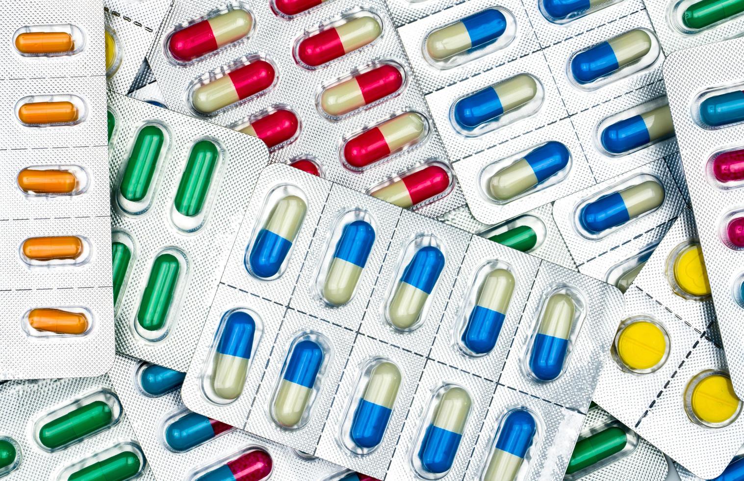 bovenaanzicht van kleurrijke tabletten en capsules pillen in blisterverpakkingen. wereldwijde gezondheidszorg en drugsgebruik met een redelijk concept. antibioticaresistentie concept. foto