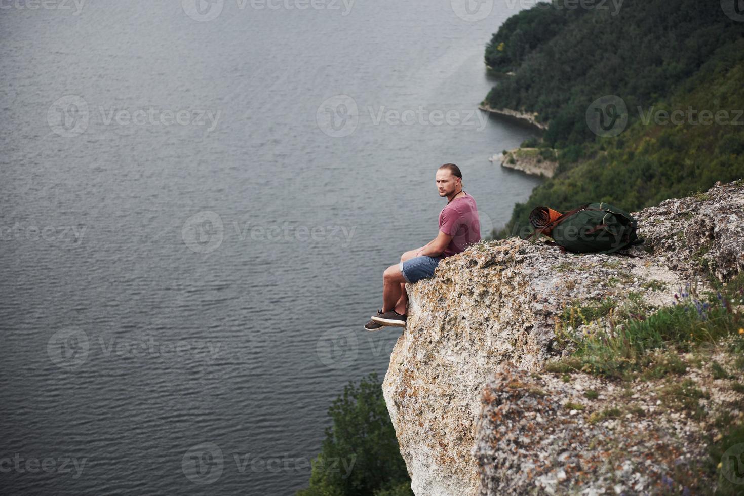 aantrekkelijke man genieten van het uitzicht op het landschap van de bergen boven het wateroppervlak. reizen levensstijl avontuur vakanties concept foto